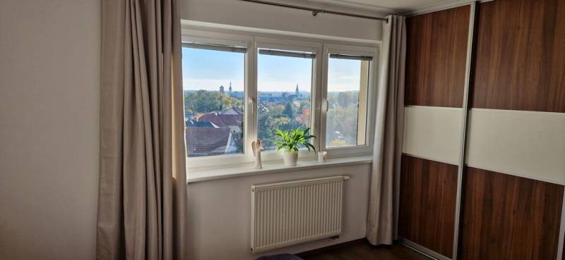 Novinka: Moderný  4-izb. mezonetový byt s balkónom a terasou. Muškát - Izba s podlahou s dreveným dekorom, oknom a skriňou v 4-izbovom byte.