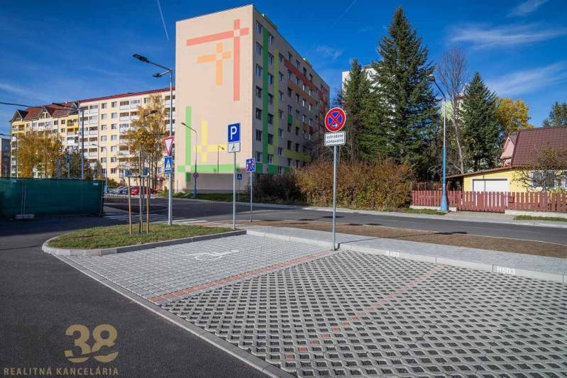 EXKLUZÍVNA PONUKA: Novostavba 3-izb. bytu v projekte Nové Nábrežie - Exteriér s bytovkou a parkoviskom v Poprade, v pozadí zeleň a domy.