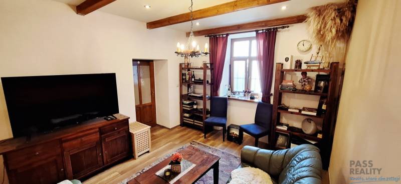 NA PRENÁJOM – odstúpenie vinotéky v srdci Starého Mesta s dušou vína - Obývacia izba s podlahou s dreveným dekorom, televízorom, policami a pohodlným nábytkom.
