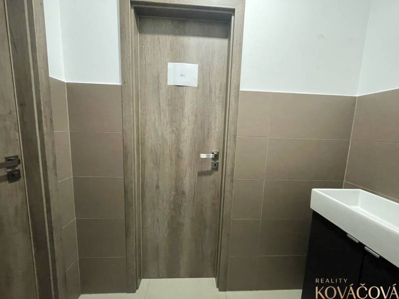 Na prenájom komerčné priestory v priemyselnej zóne v Trenčíne - Interiér obchodných priestorov s dverami na WC, obložené steny, keramické umývadlo.