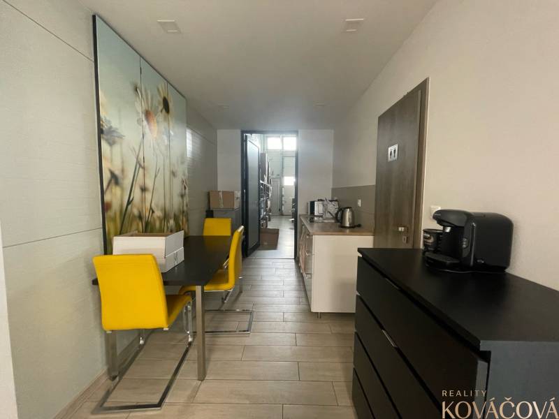 Na prenájom komerčné priestory v priemyselnej zóne v Trenčíne - Obchodné priestory s jedálenským stolom, žltými stoličkami a kuchynkou.