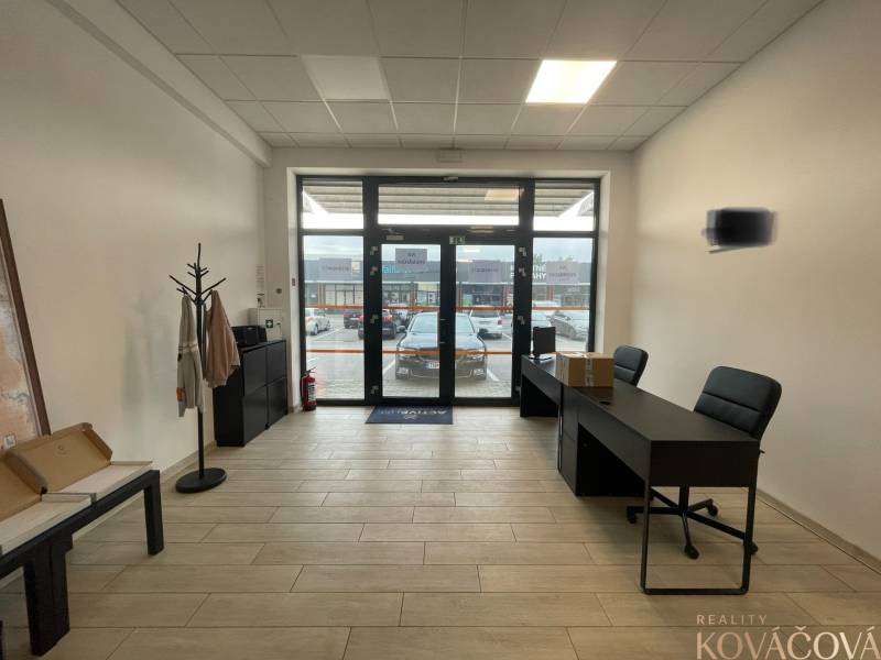 Na prenájom komerčné priestory v priemyselnej zóne v Trenčíne - Interiér obchodných priestorov s nábytkom a podlahou s dreveným dekorom.