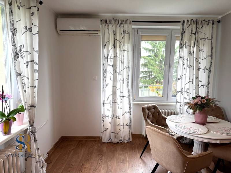 2-izbový byt v Seredi- bez rezervačnej zálohy - Jedáleň v 2-izbovom byte s podlahou s dreveným dekorom a klimatizáciou.