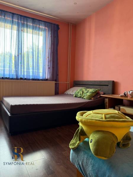 5-izbový rodinný dom v Borskom Mikuláši - bez rezervačej zálohy - Spálňa v rodinnom dome s posteľou, hračkou korytnačky a podlahou s dreveným dekorom.