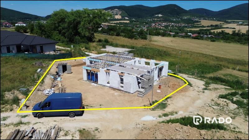 5-izbový dom 162m2 + pozemok 604m2 | Trenčianske Jastrabie - Stavba rodinného domu v Trenčianskom Jastrabí, obklopená zeleňou a kopcami.