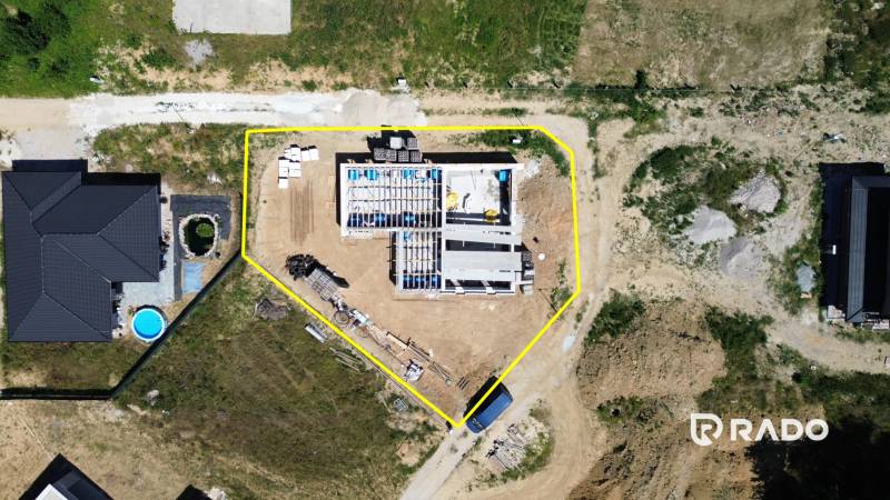5-izbový dom 162m2 + pozemok 604m2 | Trenčianske Jastrabie - Letecká snímka rozostavaného rodinného domu v Trenčianskom Jastrabí s okolím a materiálmi.