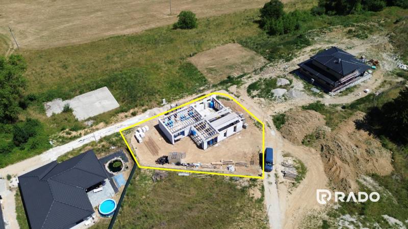 5-izbový dom 162m2 + pozemok 604m2 | Trenčianske Jastrabie - Stavba rodinného domu v Trenčianskom Jastrabí, obklopená prírodou a ďalšími stavbami.