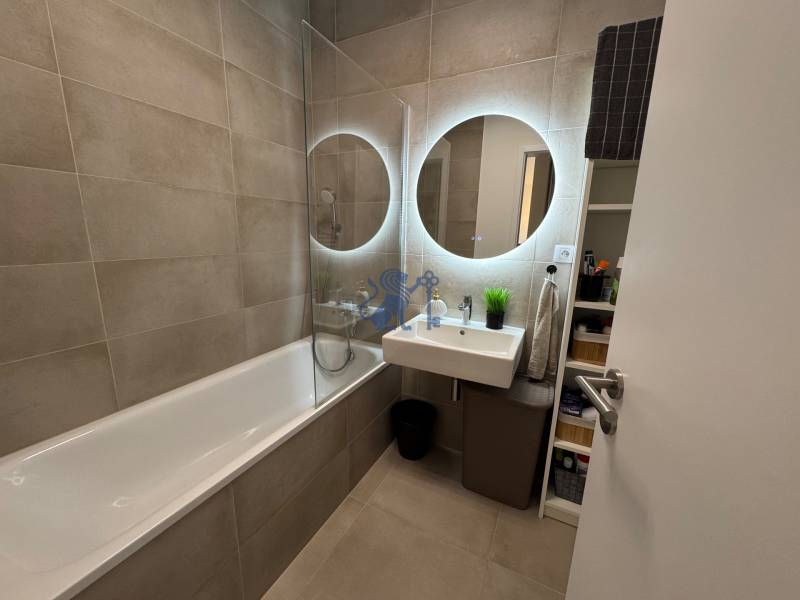 Nový 2-izbový byt na prenájom - Bory - Kúpeľňa s vaňou, umývadlom a osvetleným okrúhlym zrkadlom v 2-izbovom byte.