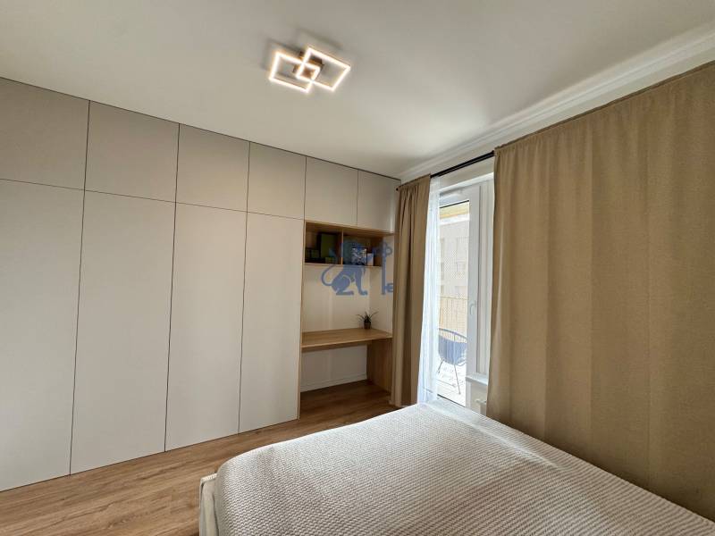 Nový 2-izbový byt na prenájom - Bory - Spálňa v 2-izbovom byte s podlahou s dreveným dekorom a vstavanou skriňou.