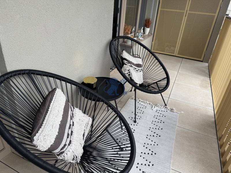 Nový 2-izbový byt na prenájom - Bory - Dve čierne kreslá s vankúšmi na balkóne v 2-izbovom byte.