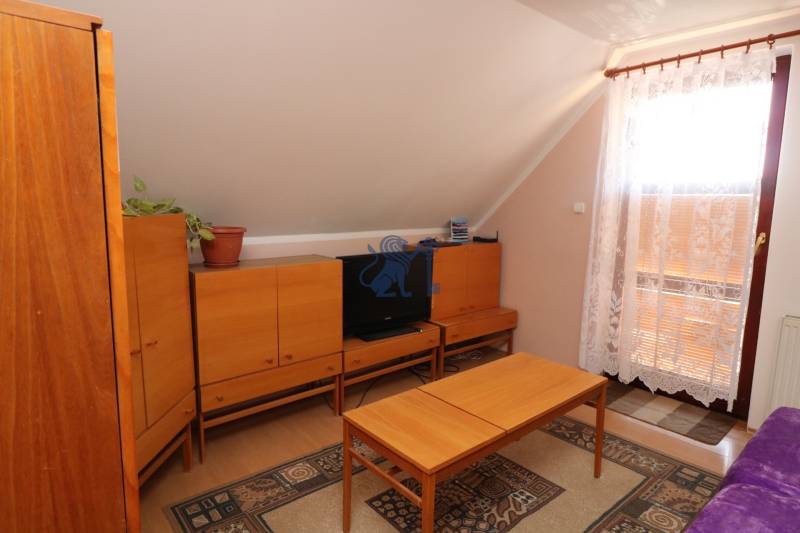 ZNÍŽENÁ cena - viacgeneračný  rodinný dom v Borinke  - Obývacia izba s dreveným nábytkom, gaučom a balkónom v rodinnom dome na ulici Borinka.