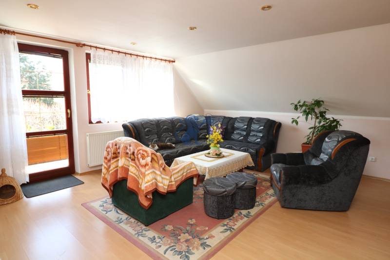 ZNÍŽENÁ cena - viacgeneračný  rodinný dom v Borinke  - Obývačka s tmavým sedením, konferenčným stolíkom a kvetinami v Rodinnom dome na ulici Borinka.