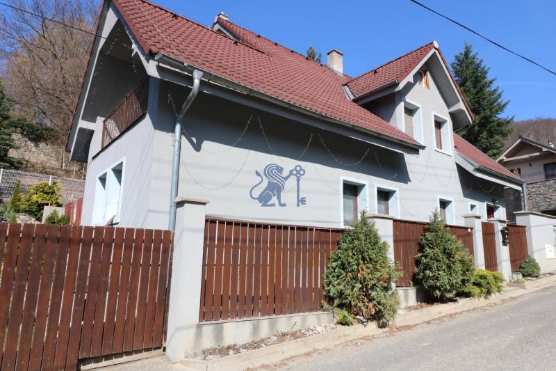 ZNÍŽENÁ cena - viacgeneračný  rodinný dom v Borinke  - Rodinný dom na ulici Borinka, s červenou strechou, plotom a zeleňou pred ním.