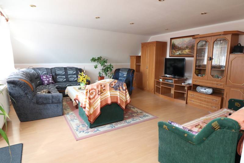 ZNÍŽENÁ cena - viacgeneračný  rodinný dom v Borinke  - Obývacia izba s dreveným nábytkom, televízorom, sedačkou, dekami; Borinka, rodinný dom.