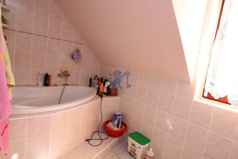 ZNÍŽENÁ cena - viacgeneračný  rodinný dom v Borinke  - Kúpeľňa s vaňou, šikmým stropom a umiestnenými čistiacimi potrebami. Dom na ulici Borinka.