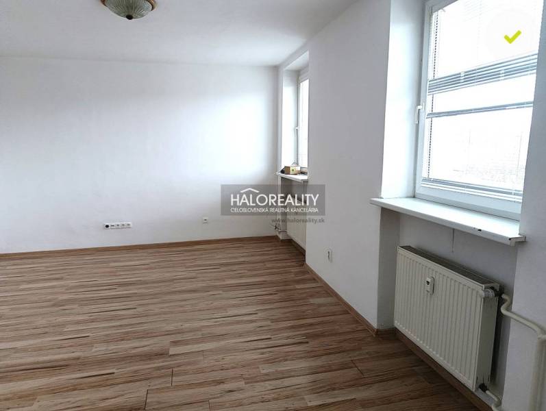 Prenájom, jednoizbový byt Nováky - Svetlá izba s podlahou s dreveným dekorom v 1-izbovom byte a veľkým oknom.