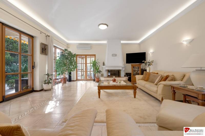 Predaj luxusná 5 izbová Vila,440 m2,pozemok 1061m2,garáž,bazén. - Priestranný obývací priestor s krbom a pohodlnými sedačkami na ulici Hrušovská vo vile.