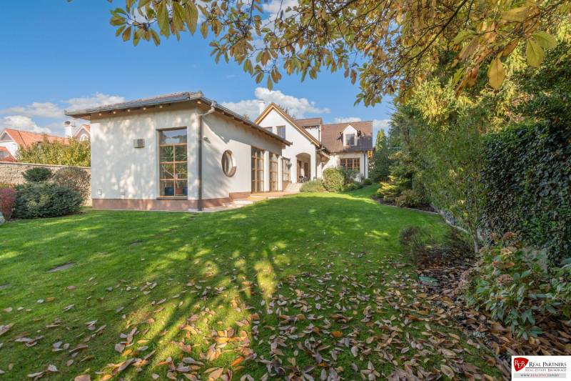 Predaj luxusná 5 izbová Vila,440 m2,pozemok 1061m2,garáž,bazén. - Vila na ulici Hrušovská, obklopená upravenou záhradou s trávnikom a opadanými listami.