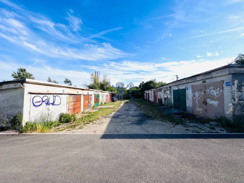 Ponúkame na prenájom Garáž na Skalickej ul. Nové Mesto - Garáže na Skalickej ceste, Bratislava - Nové Mesto, pokryté graffiti pod modrou oblohou.