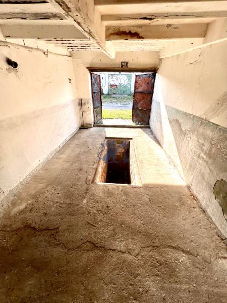 Ponúkame na prenájom Garáž na Skalickej ul. Nové Mesto - Garáže s betónovou podlahou a montážnou jamou, otvorené dvere, opotrebované steny.