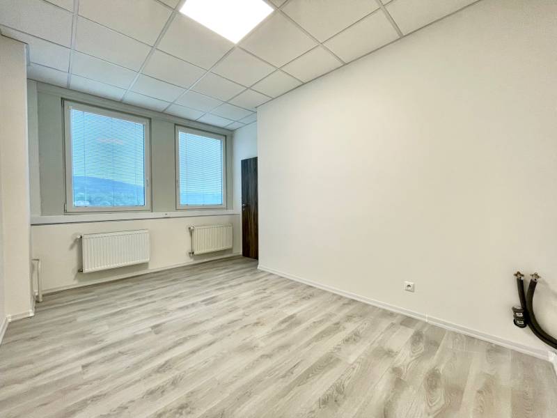 PRIESTORY, NA PRENÁJOM, CENTRUM TRENČÍN, ul. Jilemnického - Kancelárie s podlahou s dreveným dekorom a veľkými oknami so žalúziami.