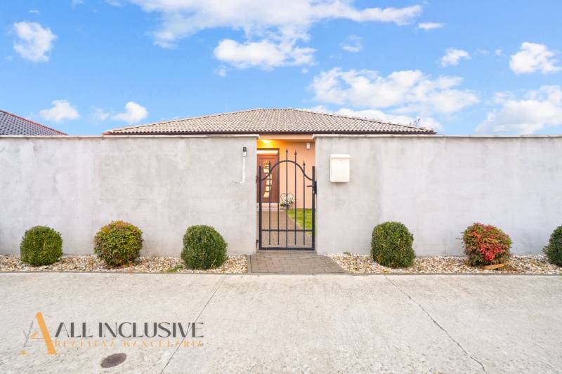 NA PREDAJ MODERNÝ 3-IZB. RD TYPU BUNGALOV V GABČÍKOVE - Rodinný dom v Gabčíkove s plotom, bránou a ozdobnými kríkmi.