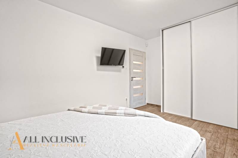 NA PREDAJ MODERNÝ 3-IZB. RD TYPU BUNGALOV V GABČÍKOVE - Spálňa v rodinnom dome s bielymi skriňami, TV na stene a podlahou s dreveným dekorom.