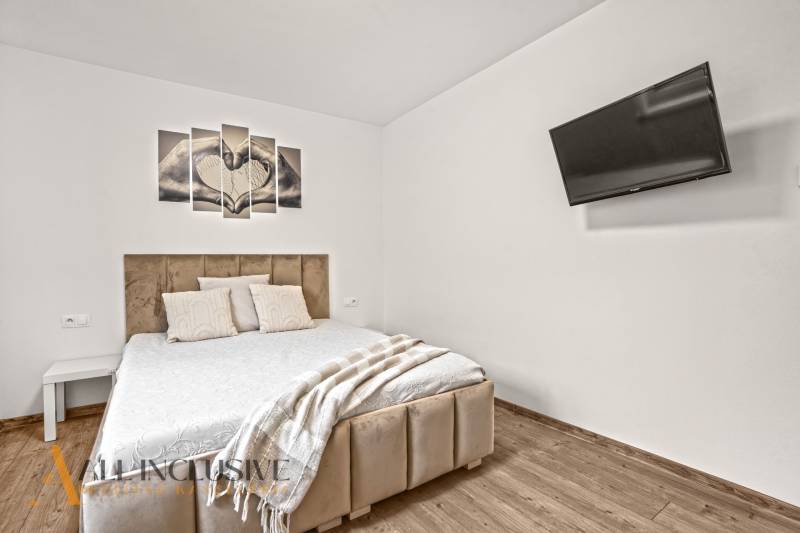 NA PREDAJ MODERNÝ 3-IZB. RD TYPU BUNGALOV V GABČÍKOVE - Spálňa v rodinnom dome s pohodlnou posteľou, televízorom a podlahou s dreveným dekorom.