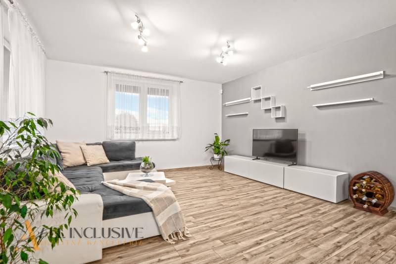 NA PREDAJ MODERNÝ 3-IZB. RD TYPU BUNGALOV V GABČÍKOVE - Obývačka v rodinnom dome s pohovkou, televízorom a podlahou s dreveným dekorom.