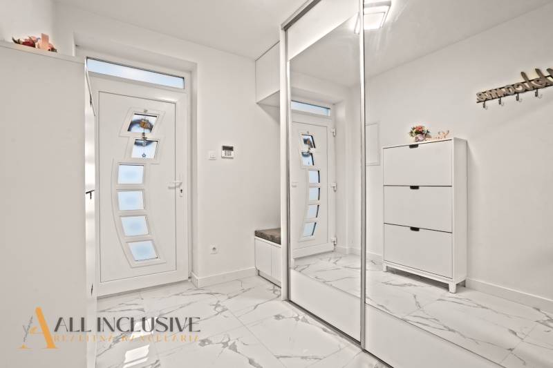 NA PREDAJ MODERNÝ 3-IZB. RD TYPU BUNGALOV V GABČÍKOVE - Interiér rodinného domu s bielymi skriňami, zrkadlom a podlahou s mramorovým dekorom.