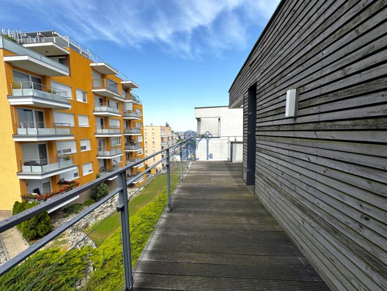 Na prenájom veľký 2- izb. byt na začiatku Koliby s terasou a wellness - Balkón s drevenou podlahou a výhľadom na bytové domy na ulici Tupého v Bratislave.