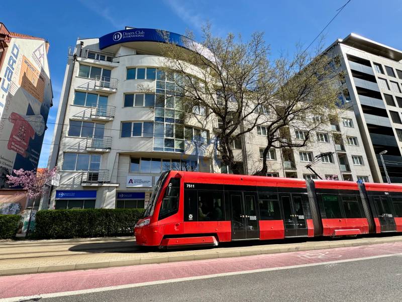 Obchodno- kancelársky priestor s výkladom na Nám. slobody - Na ulici Námestie slobody stojí červená električka pred kanceláriami.