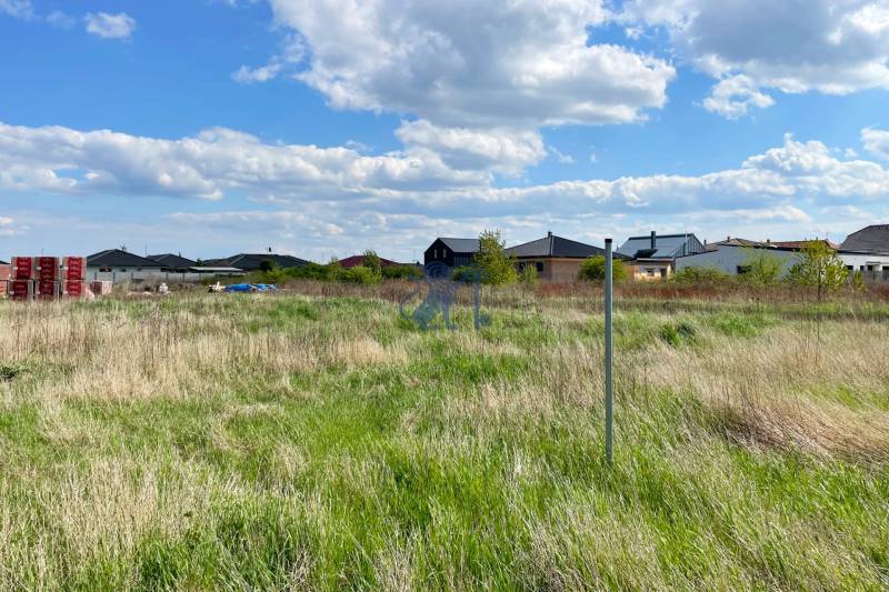 Stavebný pozemok v Bernolákove, Višňová ulica - Pozemok na ulici Višňová, vhodný na bývanie, obklopený susednými domami a zeleňou.