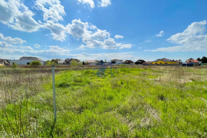 Stavebný pozemok v Bernolákove, Višňová ulica - Trávnatý pozemok na ulici Višňová, ideálny na bývanie, ponúka pokojné prostredie.