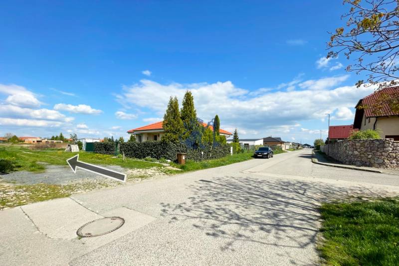 Stavebný pozemok v Bernolákove, Višňová ulica - Rodinné domy na ulici Višňová a pozemky pre bývanie, jasná slnečná obloha.