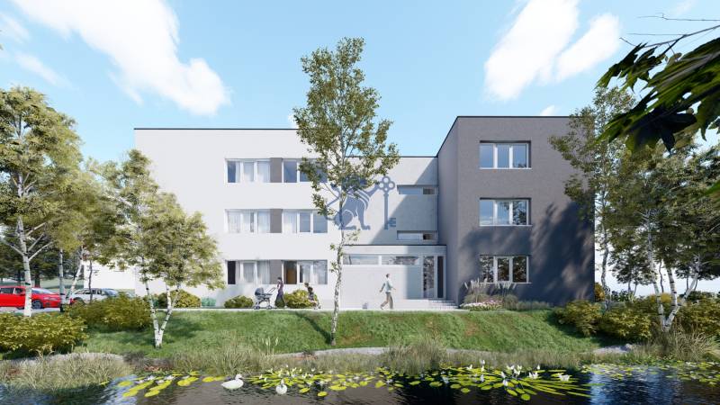 Pozemok s rozostavanou stavbou pre 12 bytov pri Senici - Budova s tromi poschodiami, obklopená stromami pri jazierku.