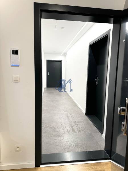 Budova s 8 apartmánmi alebo medicínske centrum, 9 park. miest- Koliba - Chodba s bielymi stenami a šedou podlahou v budove na ulici Na varte.