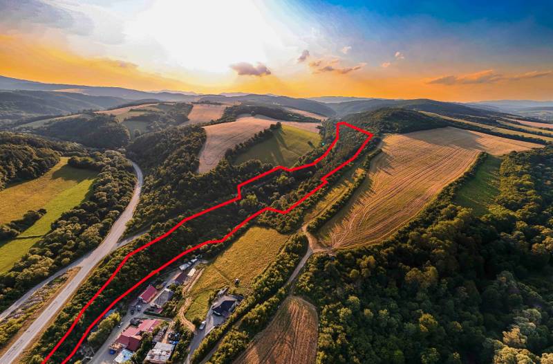 Rokycany – 70.000 m2 LESNÝ POZEMOK v podiele 1/1 - Krajina v Rokycanoch s poľnohospodárskymi a lesnými pozemkami ohraničenými červenou líniou.