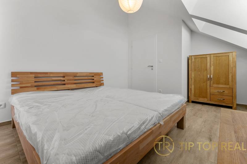 OPAL - NOVÝ a KOMPLETNE ZARIADENÝ 2,5-izbový byt s LODŽIOU a PARKOVANÍ - Spálňa so svetlou posteľou a skriňou v 2-izbovom byte, podlaha s dreveným dekorom.