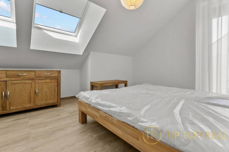 OPAL - NOVÝ a KOMPLETNE ZARIADENÝ 2,5-izbový byt s LODŽIOU a PARKOVANÍ - Podkrovná spálňa v 2-izbovom byte s nábytkom z dreva a strešnými oknami.