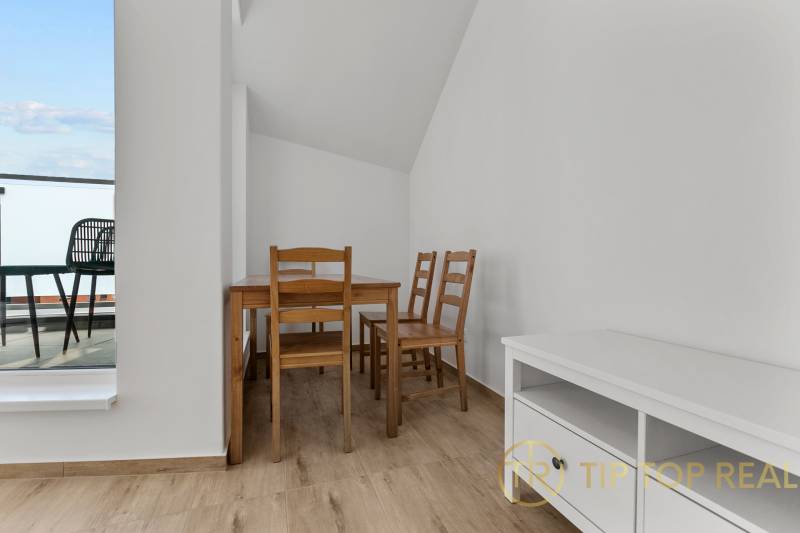 OPAL - NOVÝ a KOMPLETNE ZARIADENÝ 2,5-izbový byt s LODŽIOU a PARKOVANÍ - Jedáleň s dreveným stolom a stoličkami v 2-izbovom byte, podlaha s dreveným dekorom.