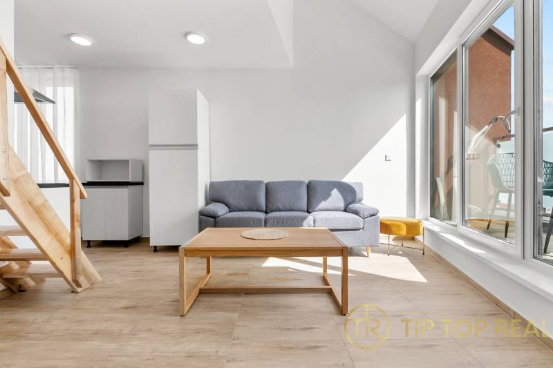 OPAL - NOVÝ a KOMPLETNE ZARIADENÝ 2,5-izbový byt s LODŽIOU a PARKOVANÍ - Obývačka v 2-izbovom byte s pohovkou, stolíkom a podlahou s dreveným dekorom.