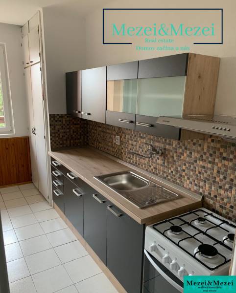 Na predaj prakticky riešený 2-izbový byt s balkónom - Kuchyňa v 2-izbovom byte s tmavým nábytkom a kachličkovým obkladom.