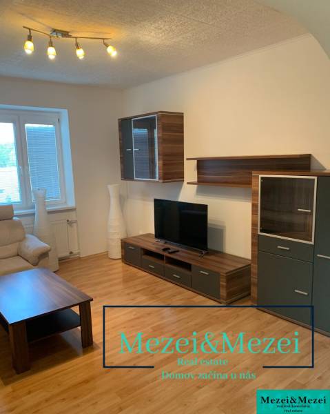 Na predaj útulný 2-izbový byt, Bratislava – Nové Mesto - Obývačka s dreveným dekorom podlahy, televízorom a pohodlnou sedačkou v 2-izbovom byte.