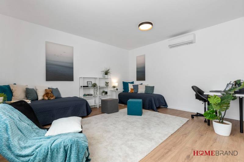 BÝVANIE VO VILA DOME - POSLEDNÝ VOĽNÝ 3-IZBOVÝ BYT SO ZÁHRADOU - Izba v 3-izbovom byte so svetlým kobercom, posteľami a pracovným stolom.