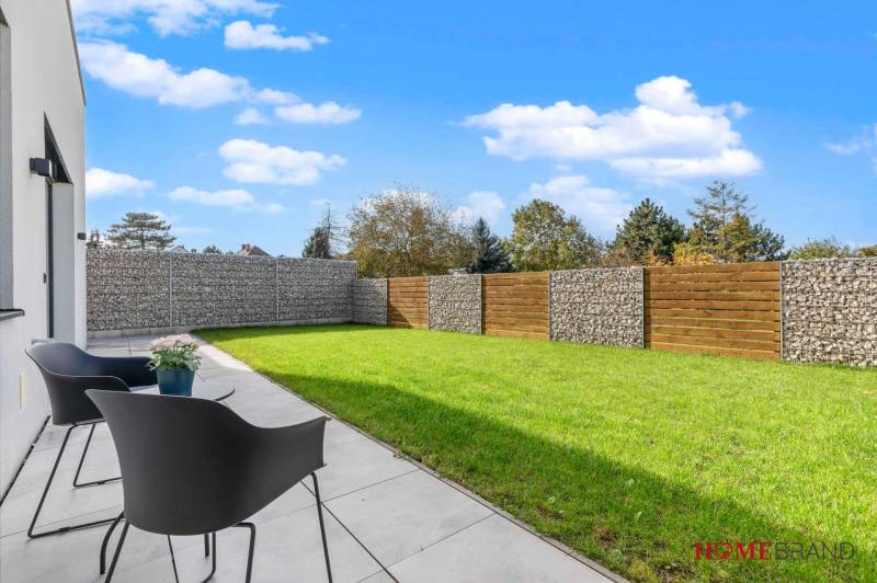 BÝVANIE VO VILA DOME - POSLEDNÝ VOĽNÝ 3-IZBOVÝ BYT SO ZÁHRADOU - Terasa s kreslami a trávnikom v 3-izbovom byte na ulici Lipnická, Dunajská Lužná.