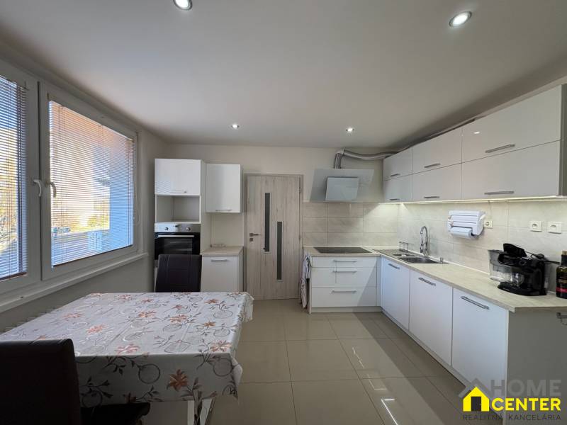 REZERVOVANÝ prenájom zrekonštruovaného 3 izbového bytu, ul. Rákócziho - Kuchyňa v 3-izbovom byte s bielymi skrinkami a obkladom, podlaha s dreveným dekorom.