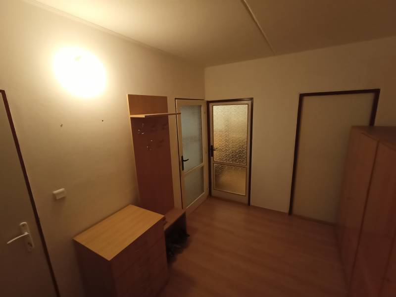 Veľký 2 izbový byt na Severe na predaj - Osvetlená predsieň s podlahou s dreveným dekorom, skrinkou, vešiakom a presklenými dverami.