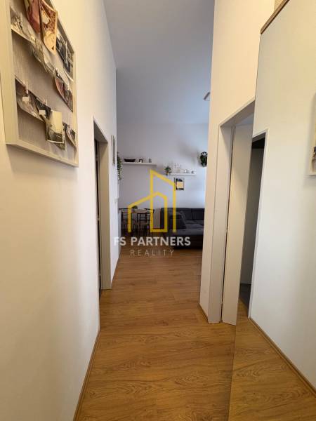 Prenájom moderného 2-izbového bytu v centre Komárna, 40 m² – Petőfiho  - Chodba v 2-izbovom byte s podlahou s dreveným dekorom a dekoráciami na stenách.