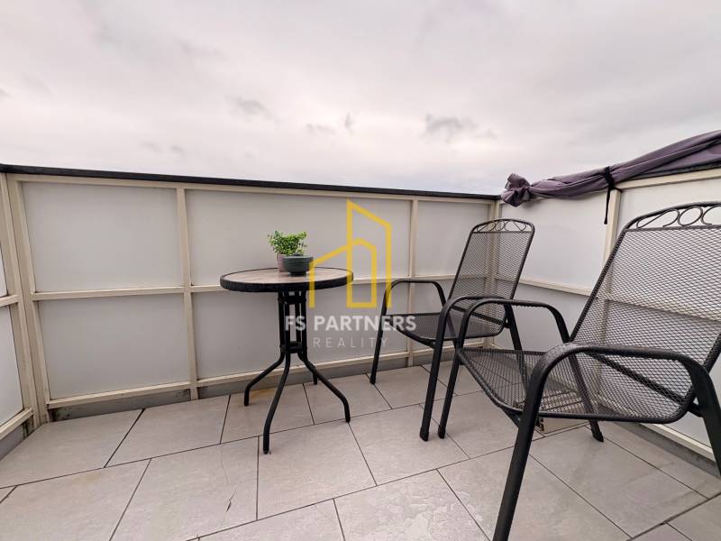 Prenájom moderného 2-izbového bytu v centre Komárna, 40 m² – Petőfiho  - Balkón 2-izbového bytu v Komárne s dvoma stoličkami a stolíkom na dlažbe.